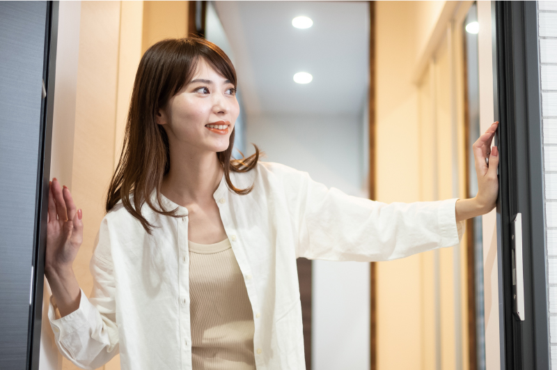 玄関のドアを開く女性